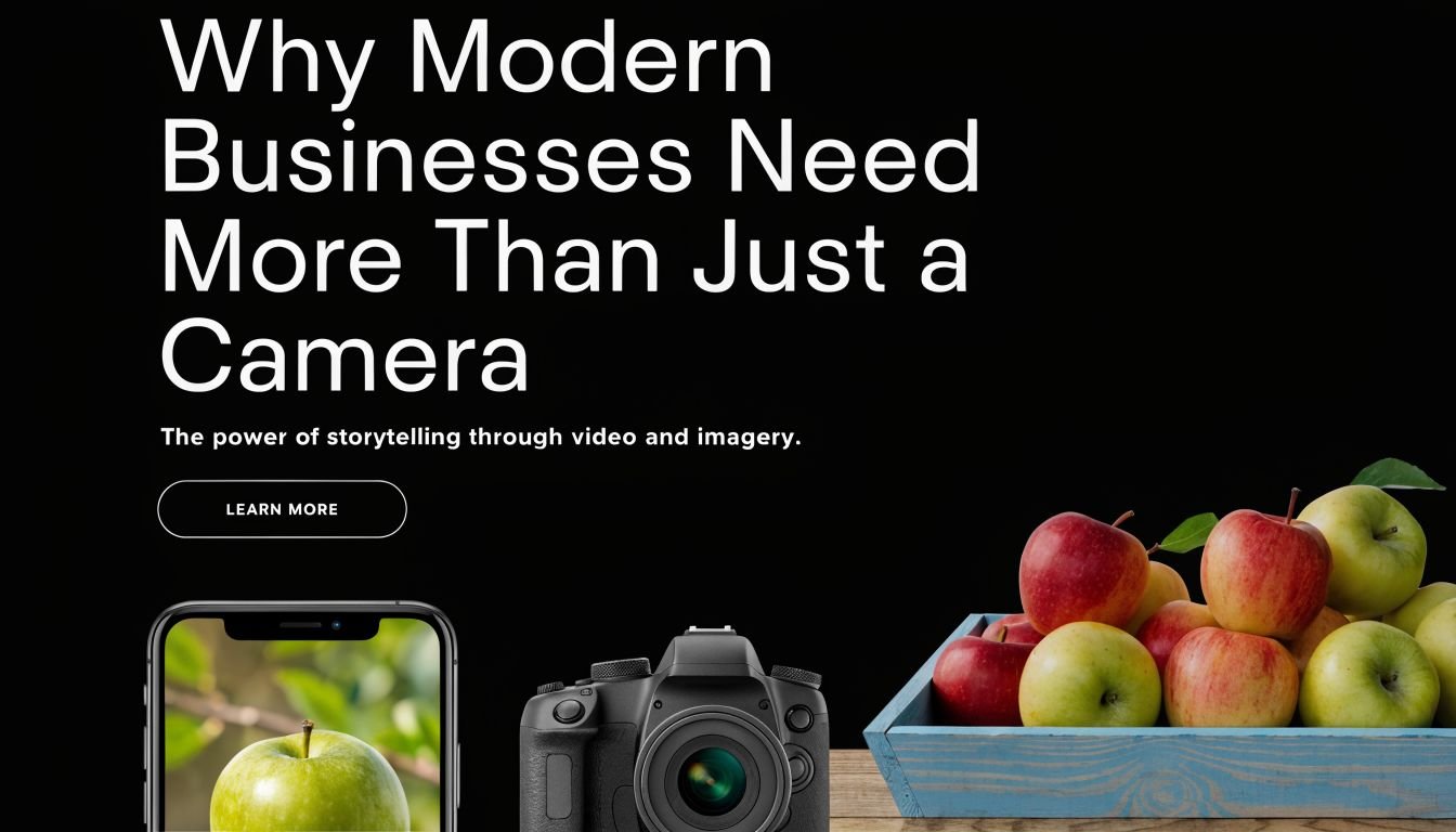 A modern business camera and smartphone placed next to a wooden crate filled with fresh apples.